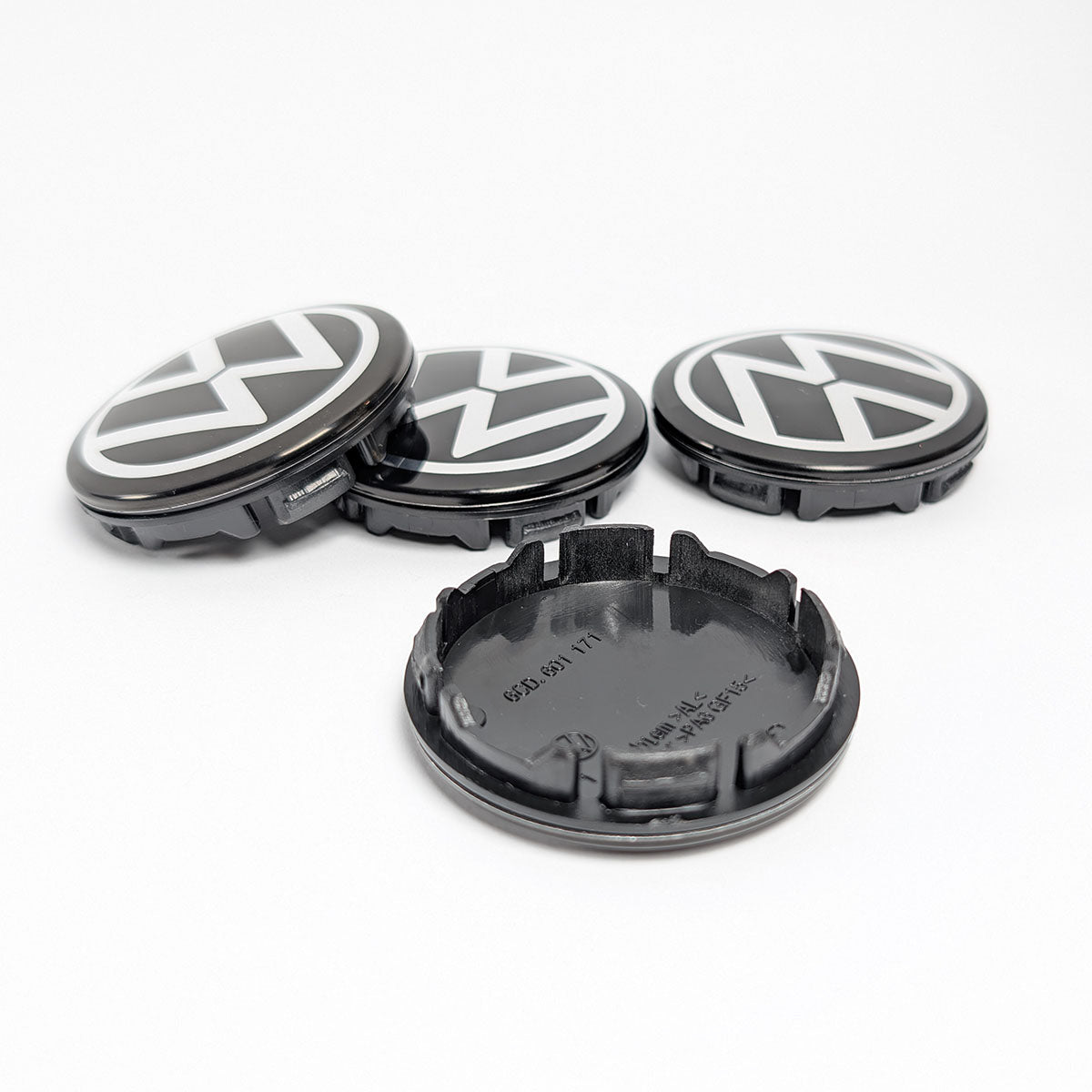 Detailansicht der schwarzen VW Nabenkappe (Teilenummer 6CD 601 171) mit Blick auf die Rückseite und Befestigungsklammern.