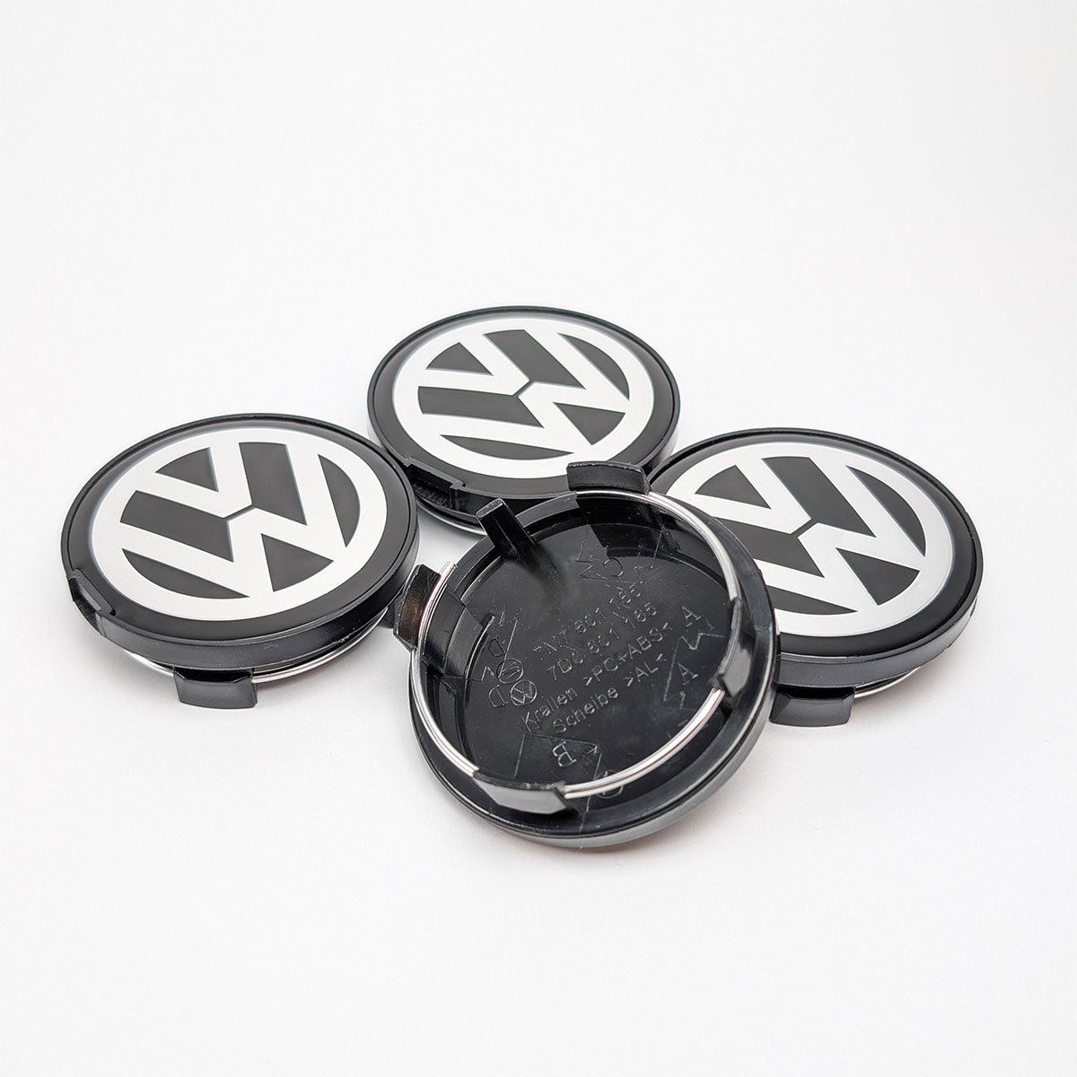 Nahaufnahme VW Felgenkappe 7D0 601 165 BXF von vorne und hinten, Krallenmechanismus