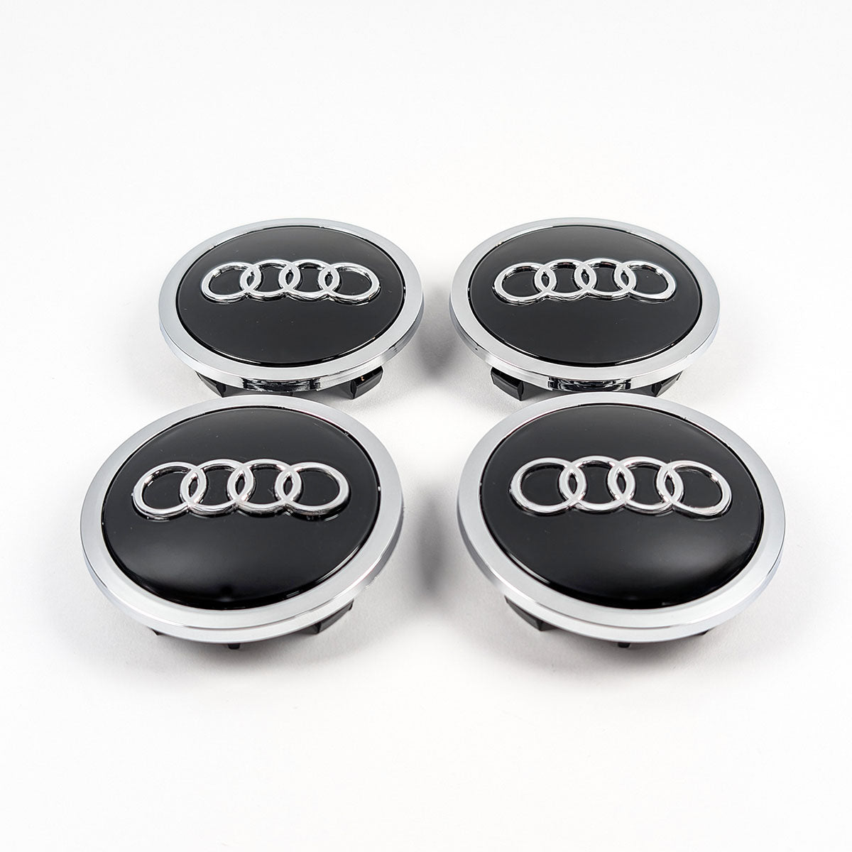 Draufsicht auf vier fabrikneue Audi Radnabenabdeckungen 69mm in Premium-Optik.
